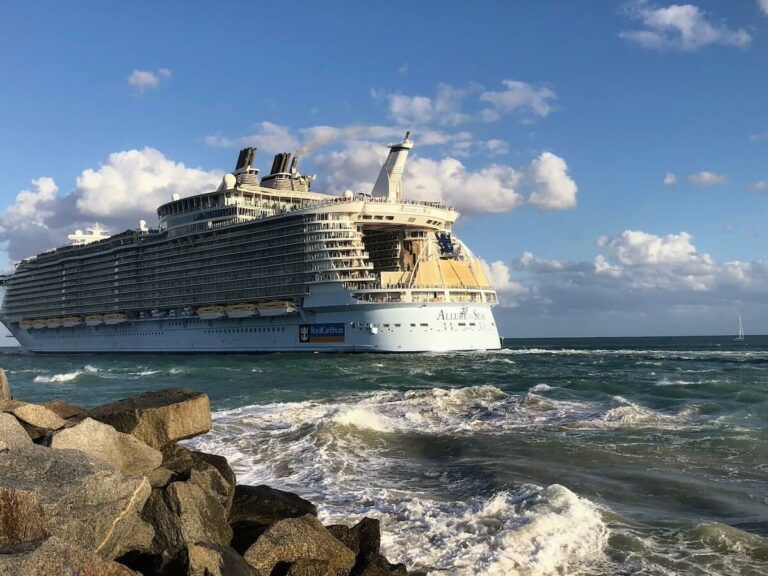 Allure of the Seas, a large cruise ship, is docked near the ocean.