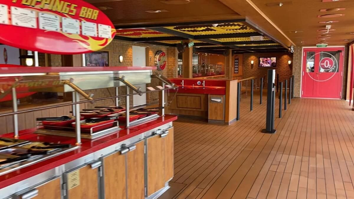A restaurant on the Carnival Mardi Gras cruise ship with a red and yellow theme.